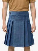 Person wearing a blue pleated skirt and brown shirt on a white background