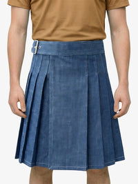 Person wearing a blue pleated skirt and brown shirt on a white background
