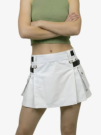 Person wearing a white skirt with black straps on a plain background