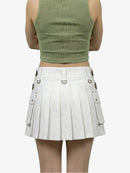 Person wearing a green crop top and white pleated skirt on a white background