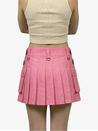 Person wearing a pink pleated skirt and beige top on a white background