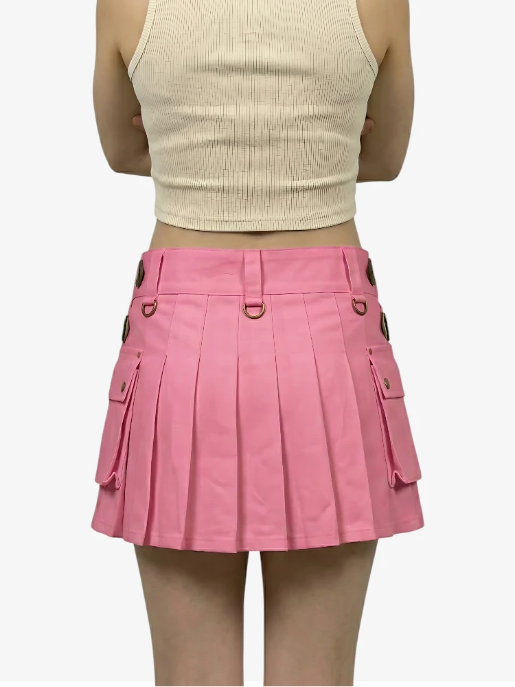 Person wearing a pink pleated skirt and beige top on a white background