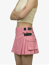 Person wearing a pink skirt with black accents on a white background