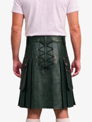 A dark green faux-leather kilt with a lace-up back and side pockets, shown on a model from the back wearing a light pink t-shirt.