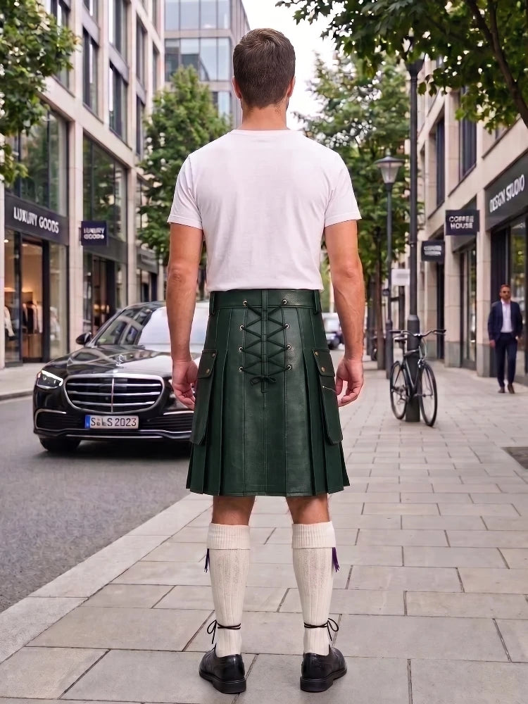 A man viewed from behind wearing a dark green leather kilt with lace-up back detailing, a white t-shirt, and white knee-high socks, standing on a city sidewalk.