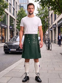 A man stands on a city sidewalk wearing a dark green leather kilt with silver-tone metal grommets, a white t-shirt, white knee-high socks, and black leather shoes. A black Mercedes-Benz car and urban buildings are visible in the background.