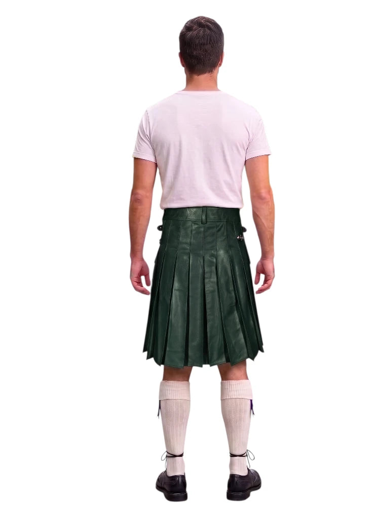 A man shown from the back wearing a dark green pleated kilt, a light pink t-shirt, cream knee-high socks, and black shoes, isolated on a white background.