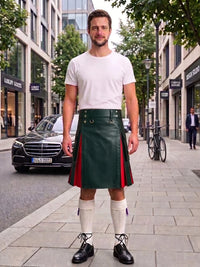 A man stands on a city sidewalk wearing a dark green leather kilt with silver-tone metal grommets, a white t-shirt, white knee-high socks, and black leather shoes. A black Mercedes-Benz car and urban buildings are visible in the background.