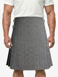 Person wearing a gray herringbone kilt on a white background