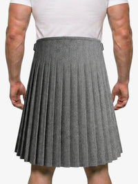 Person wearing a gray pleated kilt on a white background