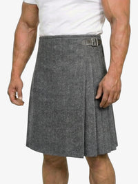Person wearing a gray patterned kilt on a white background