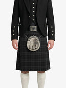 Person wearing a black kilt with a silver sporran on a white background