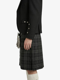 Person wearing a black blazer and plaid kilt on a white background