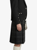 Person wearing a black jacket and plaid kilt on a white background