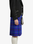 Person wearing a black blazer and blue plaid kilt on a white background
