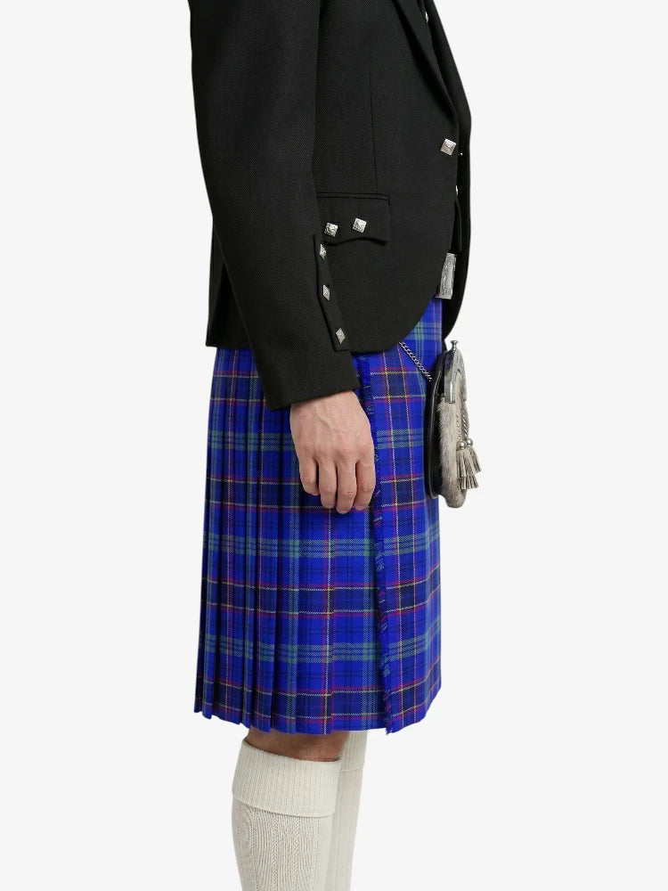 Person wearing a black blazer and blue plaid kilt on a white background