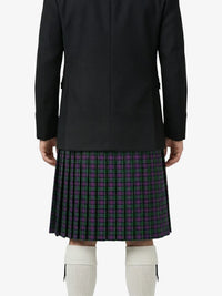 Person wearing a black coat and plaid kilt on a white background