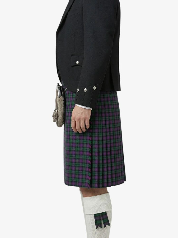 Person wearing a black jacket and plaid kilt on a white background