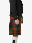 Person wearing a black jacket and red plaid kilt on a white background