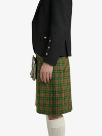 Person wearing a black jacket and green plaid kilt on a white background