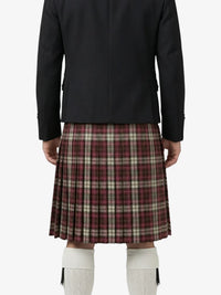 Person wearing a black jacket and plaid kilt on a white background