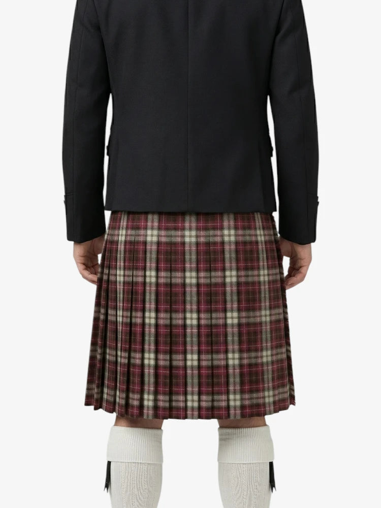 Person wearing a black jacket and plaid kilt on a white background