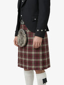 Person wearing a black jacket and red plaid kilt on a white background