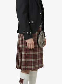Person wearing a black jacket and red plaid kilt on a white background