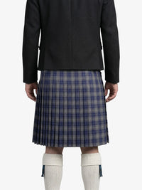 Person wearing a black jacket and plaid kilt on a white background
