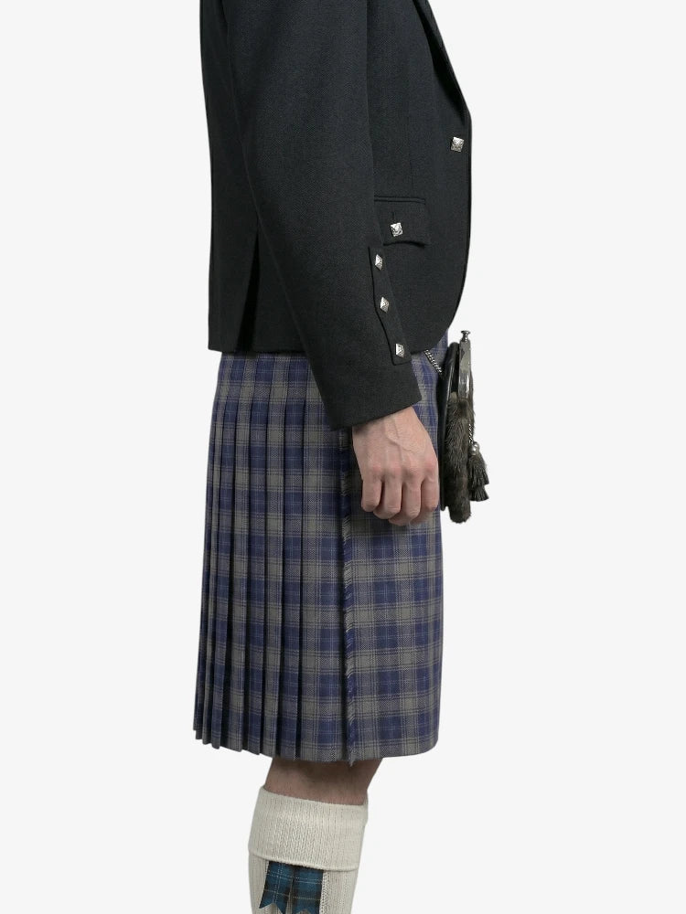 Person wearing a dark jacket and plaid kilt on a white background