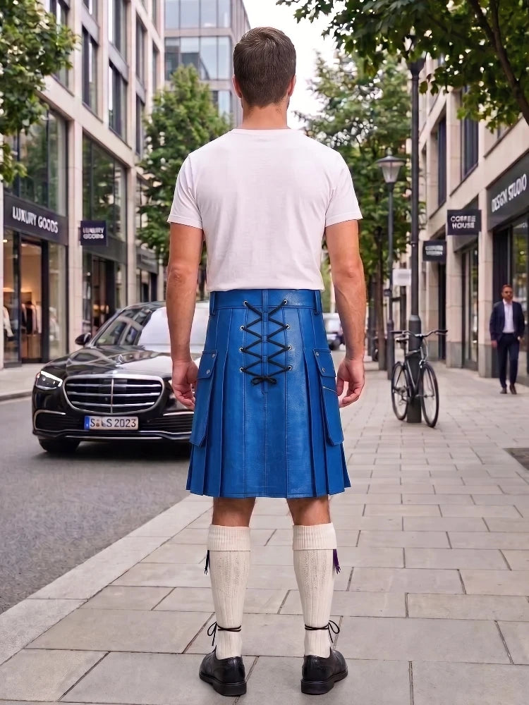 A man viewed from behind wearing a bright blue leather kilt with black lace-up detailing, a white t-shirt, white knee-high socks, and black shoes, standing on a city sidewalk.