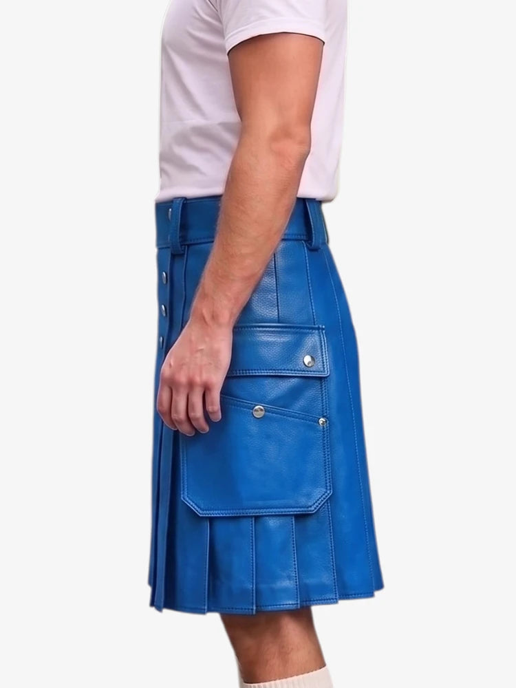 A man wearing a bright blue faux-leather kilt with multiple flap pockets and silver snap buttons, paired with a white t-shirt, shown from a side profile against a light gray background.
