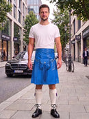 A man standing on a city sidewalk wearing a bright blue leather kilt with a white t-shirt, white knee-high socks, and black leather shoes. The background shows a street scene with buildings, a parked black Mercedes, and a bicycle.