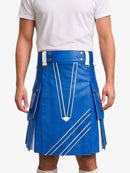 A man wearing a bright blue leather kilt with white contrast stitching and silver hardware, paired with a white t-shirt, shown from the chest down against a light gray background.