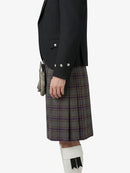 Person wearing a black blazer and plaid kilt on a white background
