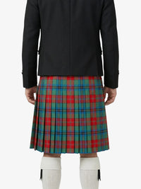 Person wearing a black jacket and a red, green, and blue plaid kilt on a white background
