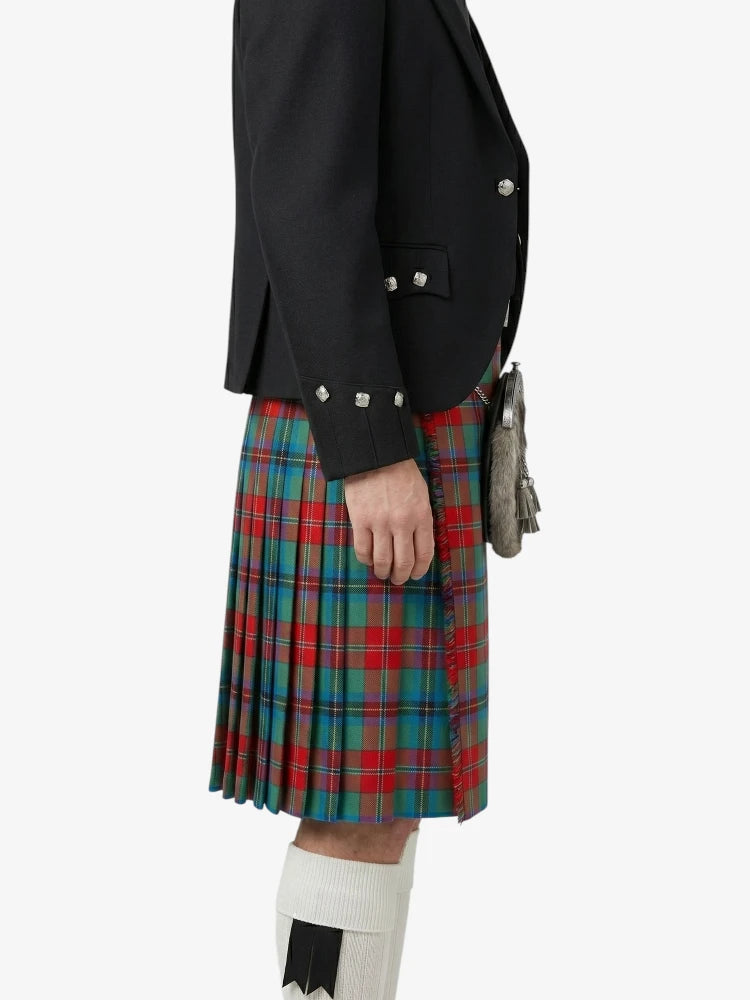 Person wearing a black jacket and a red, green, and blue plaid kilt on a white background