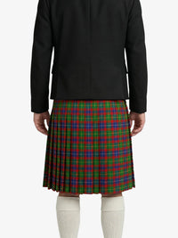 Person wearing a black jacket and red, green, and blue plaid kilt on a white background