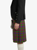 Person wearing a black jacket and a red, green, and blue plaid kilt on a white background