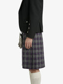 Person wearing a black jacket and plaid Kilt on a white background