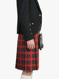 Person wearing a black jacket and red plaid kilt on a white background