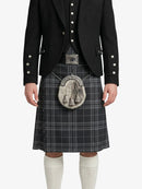 Person wearing a black jacket, plaid kilt, and white knee-high socks on a white background