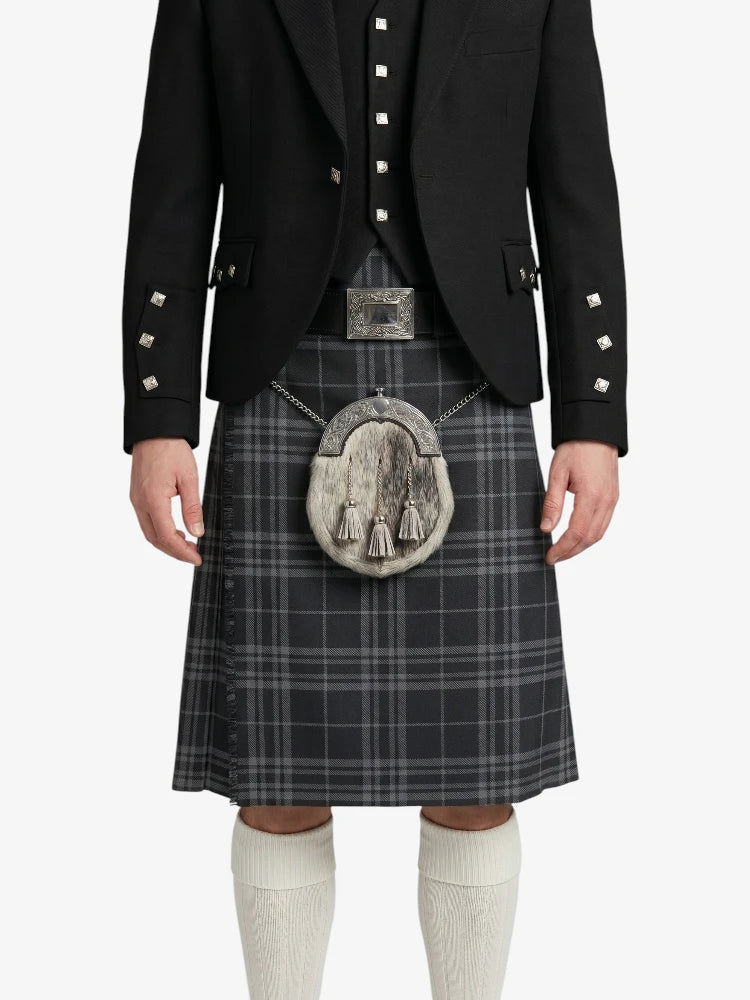 Person wearing a black jacket, plaid kilt, and white knee-high socks on a white background