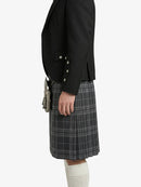 Person wearing a black blazer and gray plaid kilt on a white background