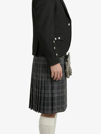 Person wearing a black jacket and gray plaid kilt on a white background