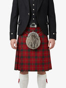 Person wearing a red tartan kilt with a black jacket and white socks on a white background