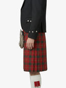 Person wearing a red plaid kilt with a black jacket on a white background