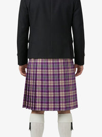 Person wearing a black jacket and purple plaid kilt on a white background