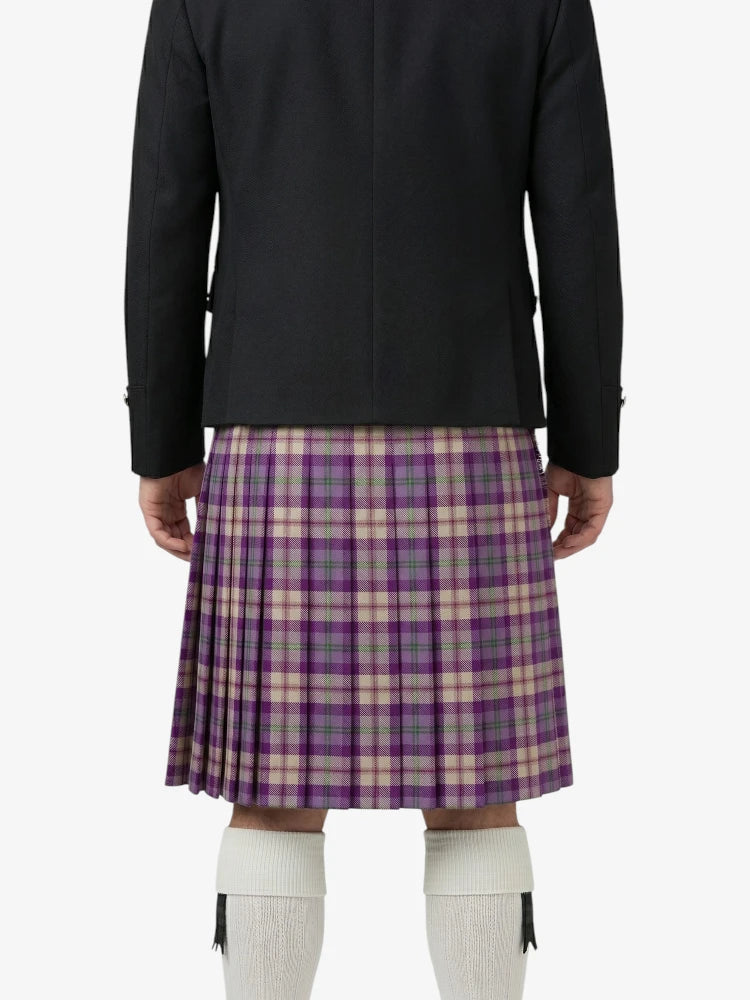 Person wearing a black jacket and purple plaid kilt on a white background