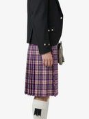 Person wearing a black jacket and purple plaid kilt on a white background